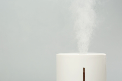 Modern air humidifier on light grey background, closeup. Space for text