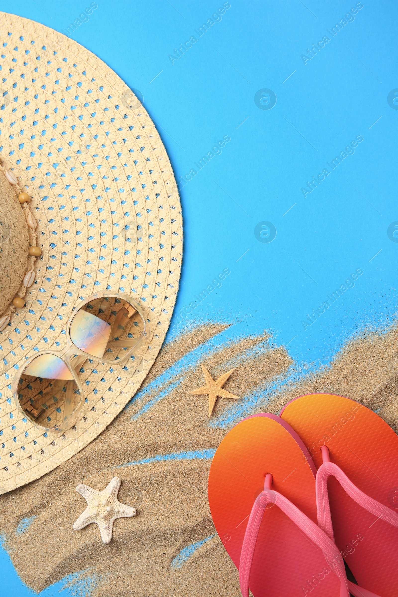 Photo of Flat lay composition with beach accessories on light blue background