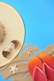 Photo of Flat lay composition with beach accessories on light blue background