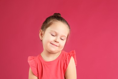 Photo of Portrait of cute little girl on pink background