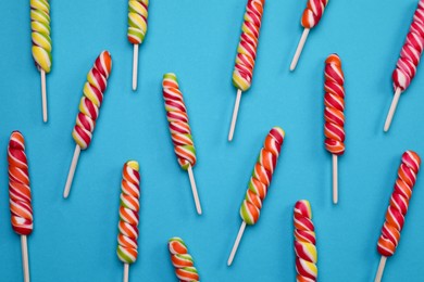 Sweet lollipops on blue background, flat lay