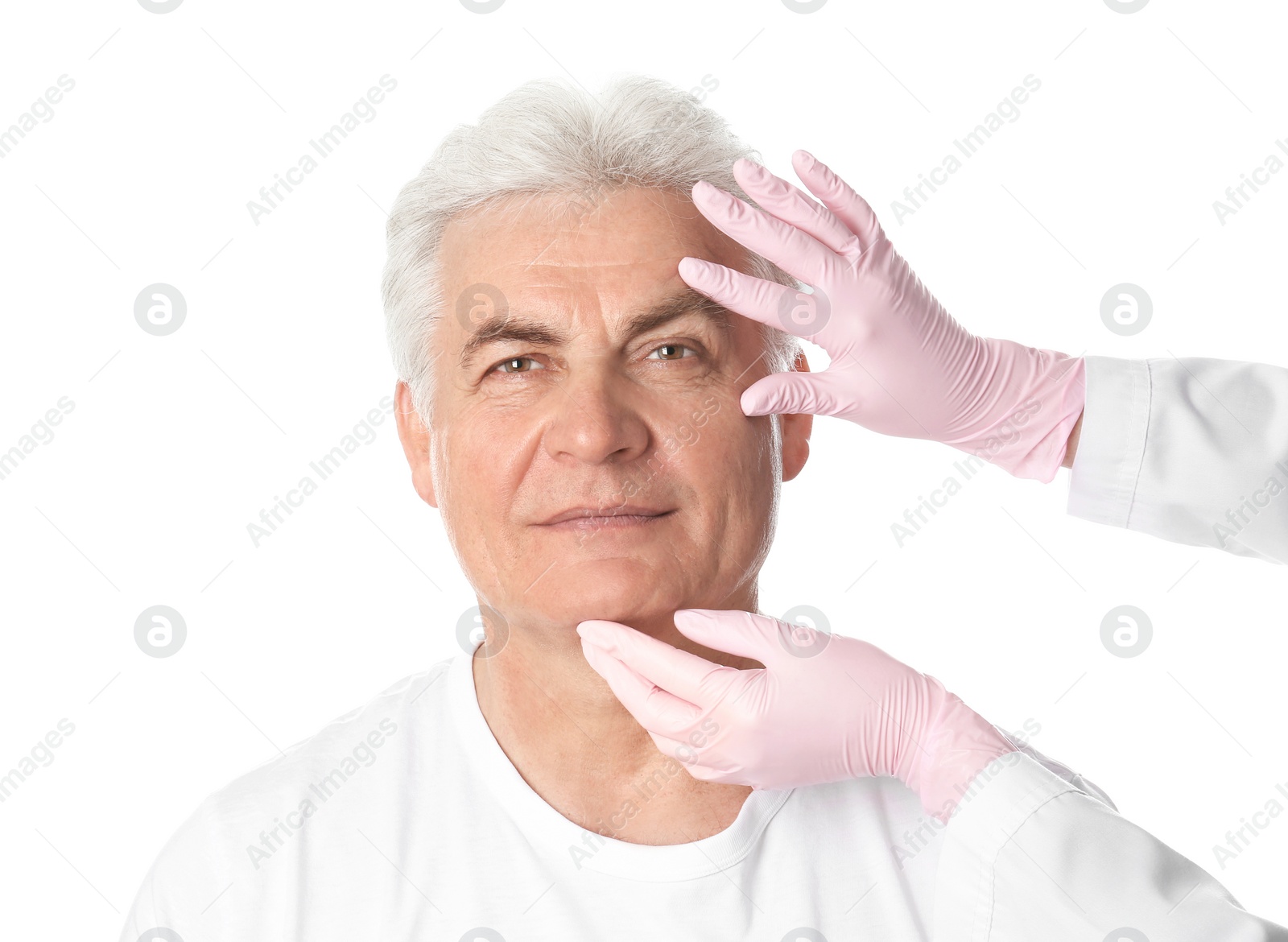 Photo of Doctor examining man's face before plastic surgery operation on white background