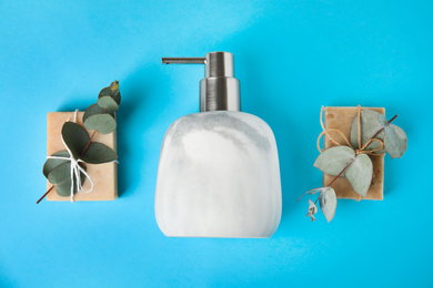 Flat lay composition with marble soap dispenser on light blue background