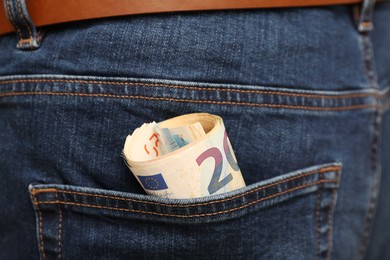 Photo of Euro banknotes in pocket of jeans, closeup. Spending money