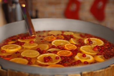 Hot mulled wine with orange and cranberries in pot, closeup