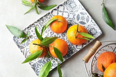 Flat lay composition with ripe tangerines on light background