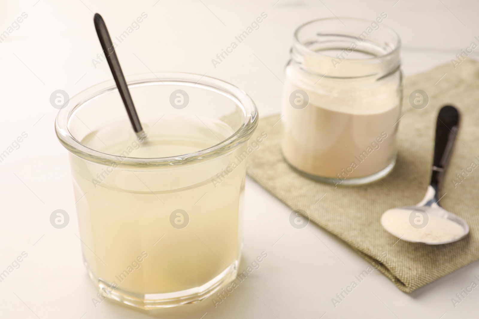 Photo of Agar-agar jelly and powder on white marble table