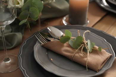 Festive table setting with beautiful eucalyptus branches indoors, closeup