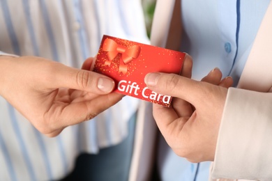 Women holding red gift card, closeup view