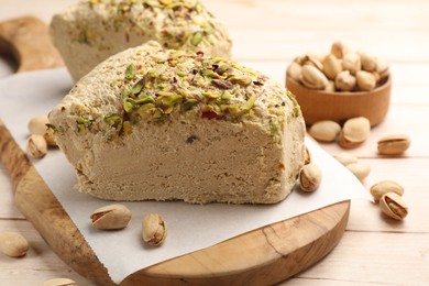 Photo of Tasty halva with pistachios on table, closeup