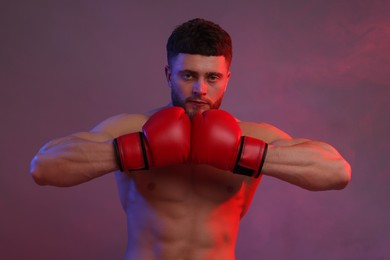 Photo of Man in boxing gloves on color background