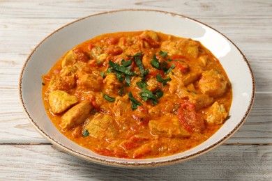 Photo of Delicious chicken curry on wooden table, closeup