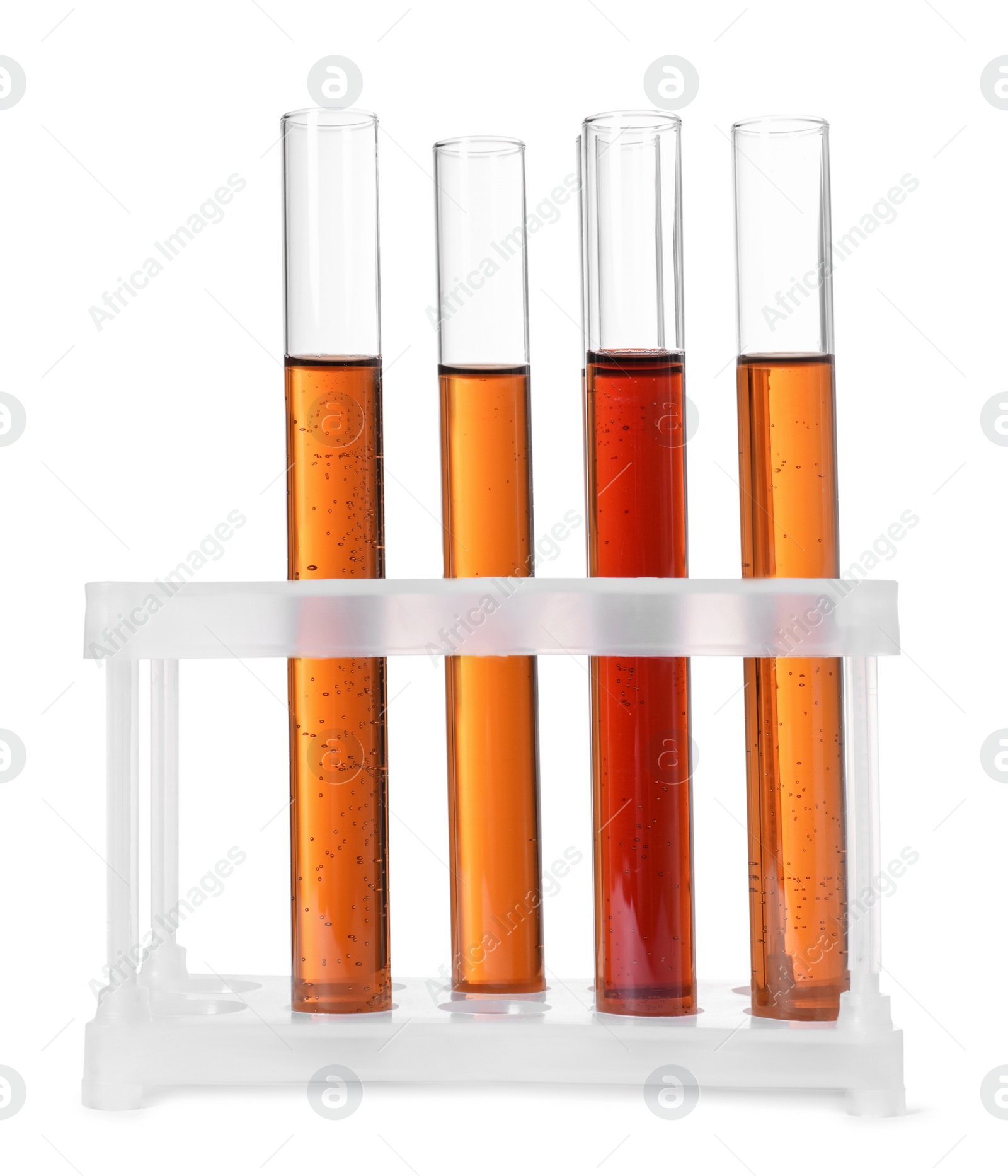 Photo of Test tubes with brown liquid in stand on white background