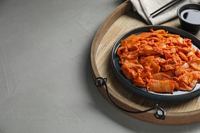 Delicious kimchi with Chinese cabbage and sauce on light grey table, space for text