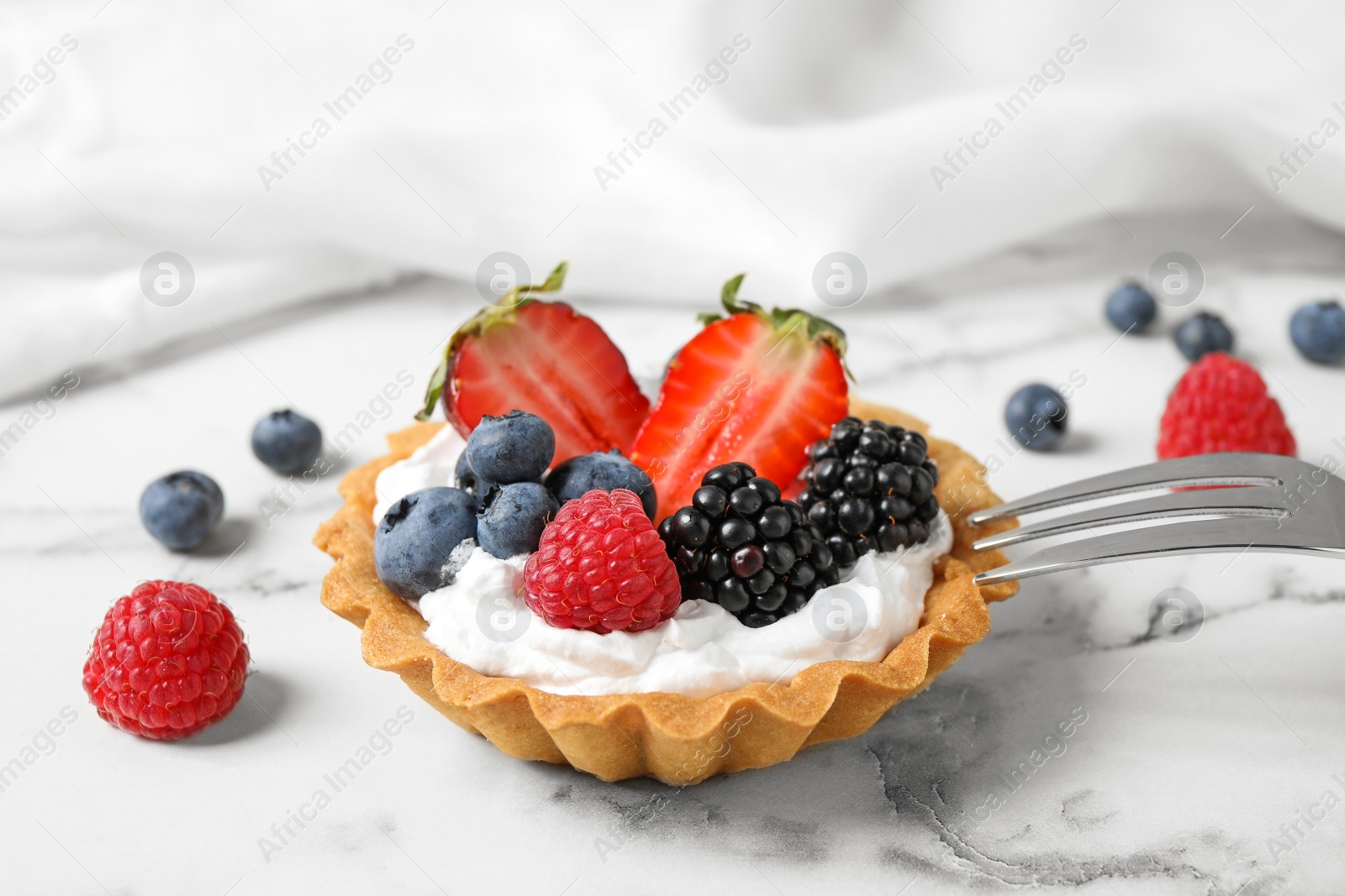 Photo of Tart with different berries on marble table. Delicious pastries