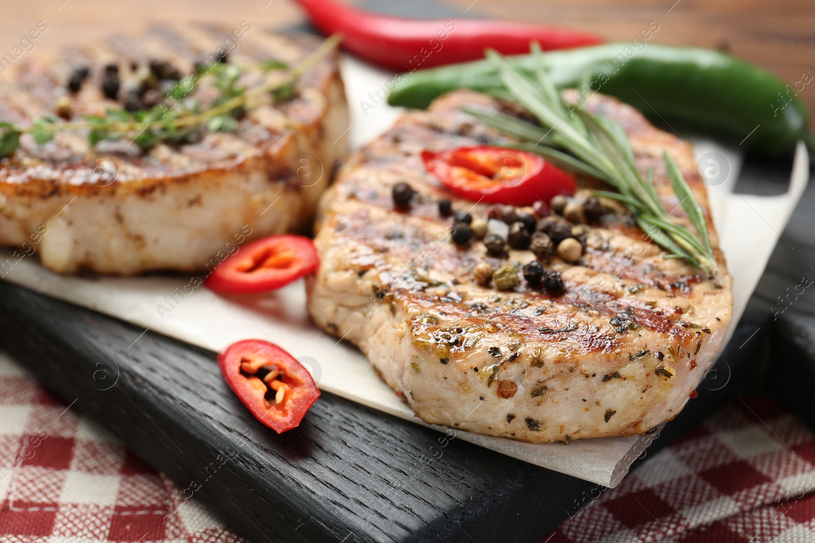 Photo of Delicious grilled pork steaks with spices on table, closeup