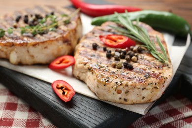 Photo of Delicious grilled pork steaks with spices on table, closeup