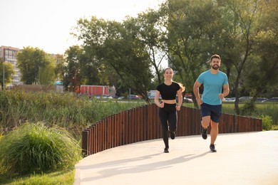 Photo of Healthy lifestyle. Happy couple running outdoors, space for text