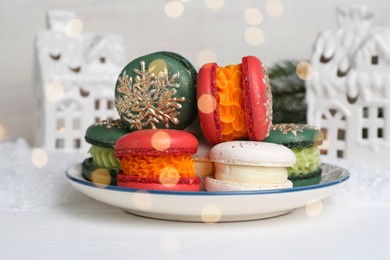 Different decorated Christmas macarons on white table, closeup