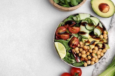 Photo of Delicious salad with chickpeas, vegetables and balsamic vinegar on white table, flat lay. Space for text