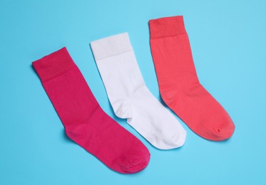 Different socks on light blue background, flat lay