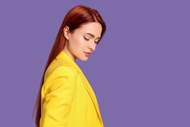 Stylish woman with red dyed hair on purple background, space for text