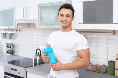 Photo of Man with bottle of protein shake in kitchen