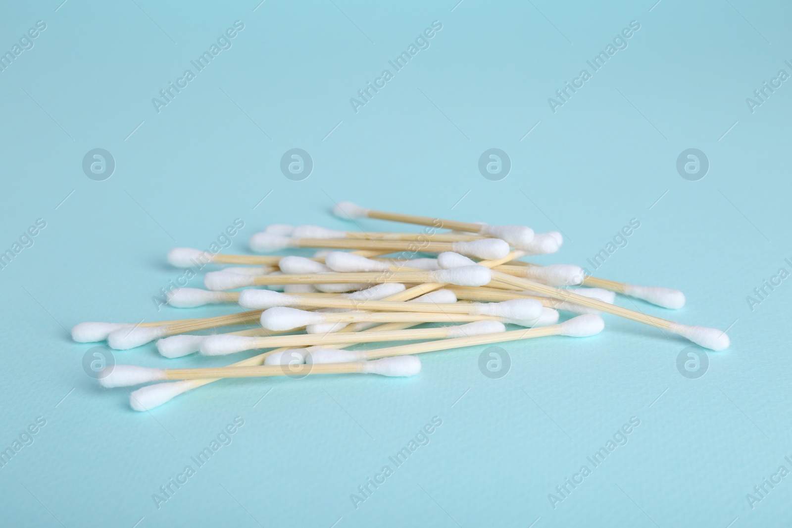 Photo of Wooden cotton buds on light blue background