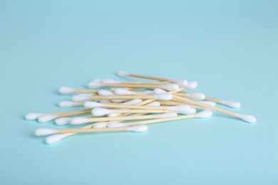 Photo of Wooden cotton buds on light blue background