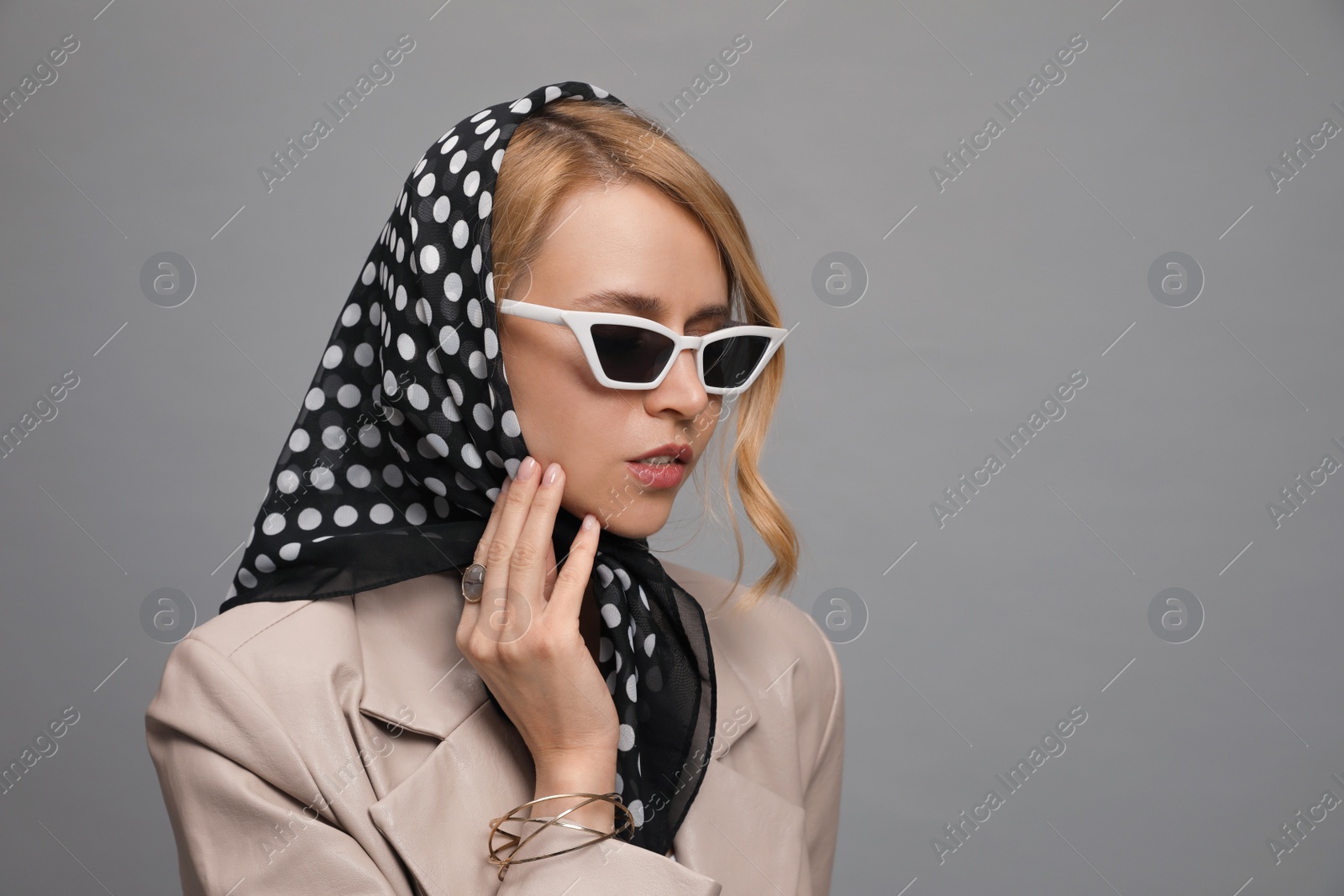 Photo of Young woman with sunglasses and stylish bandana on grey background. Space for text