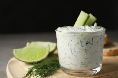 Photo of Glass bowl of Tzatziki cucumber sauce on wooden board, space for text