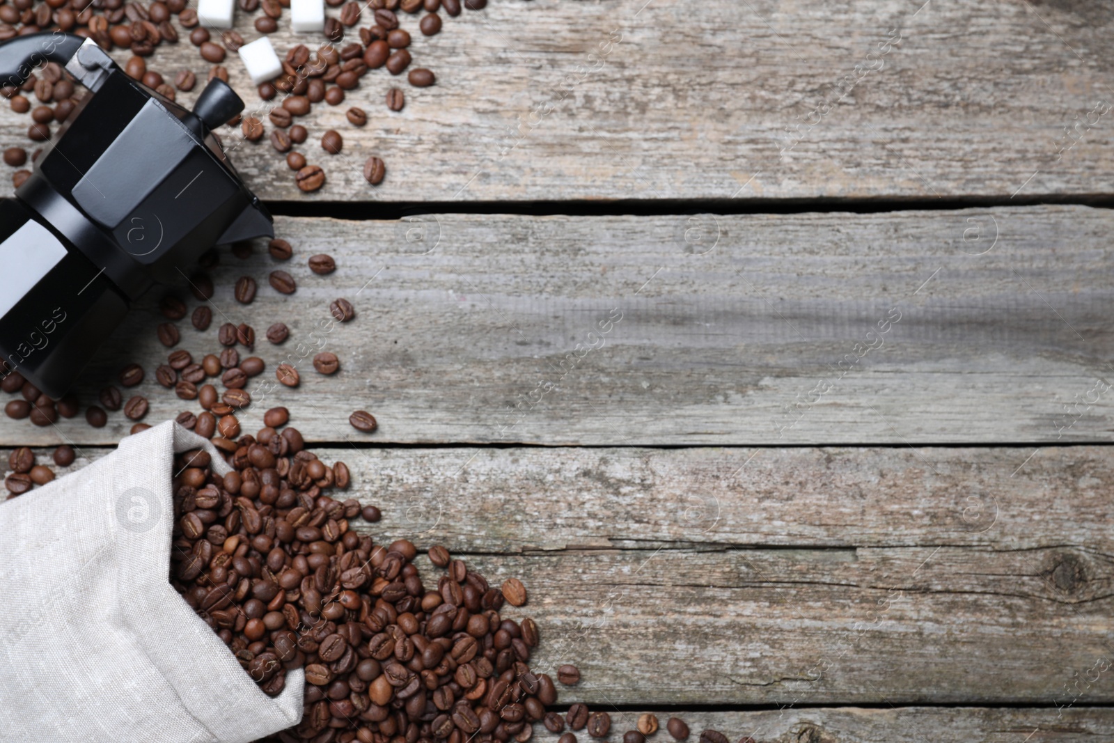 Photo of Bag with roasted coffee beans and moka pot on wooden table, flat lay. Space for text