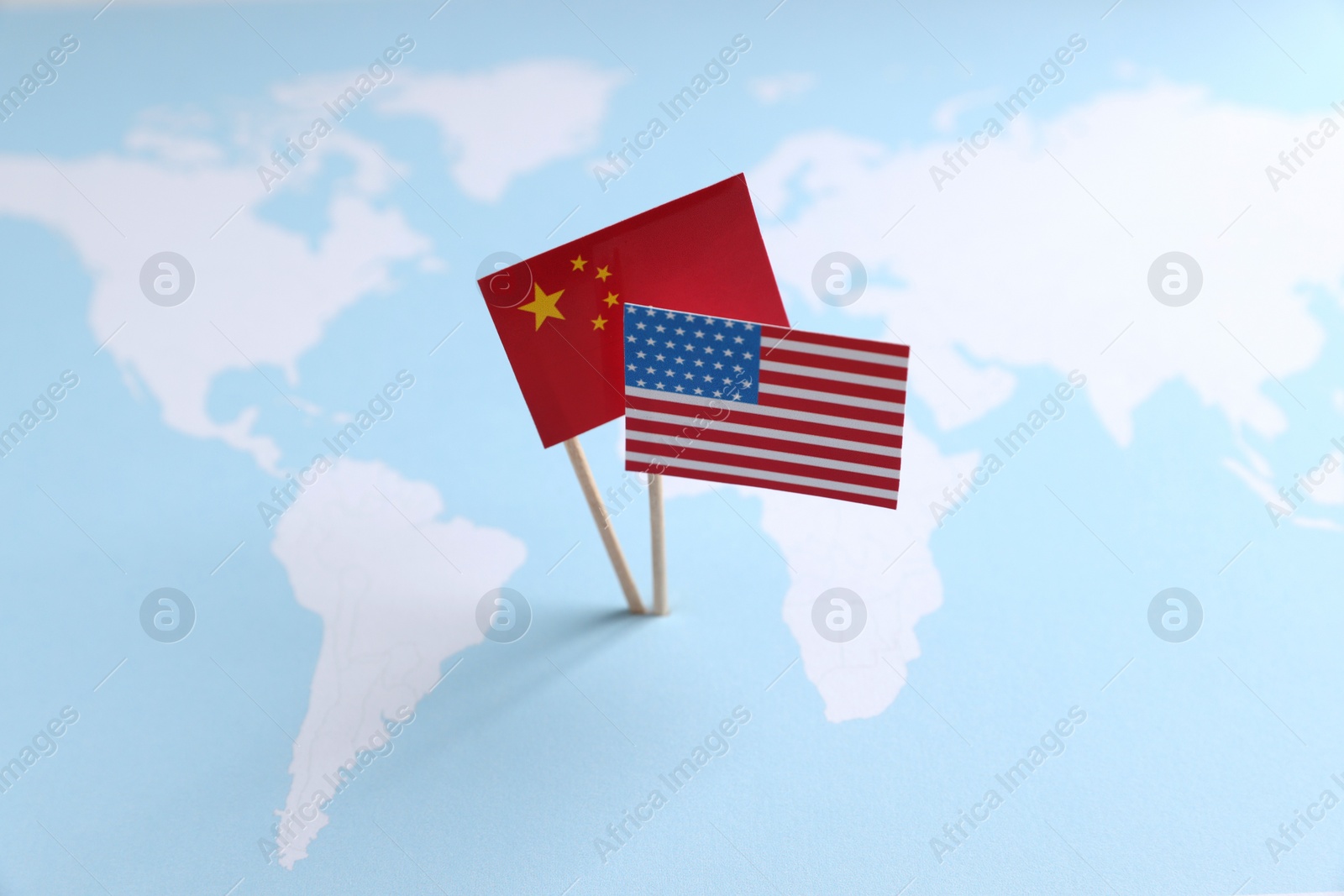 Photo of American and Chinese flags on world map. Trade war concept