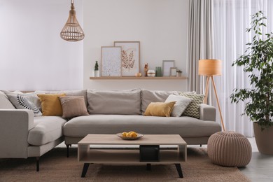 Photo of Stylish living room interior with comfortable grey sofa and coffee table