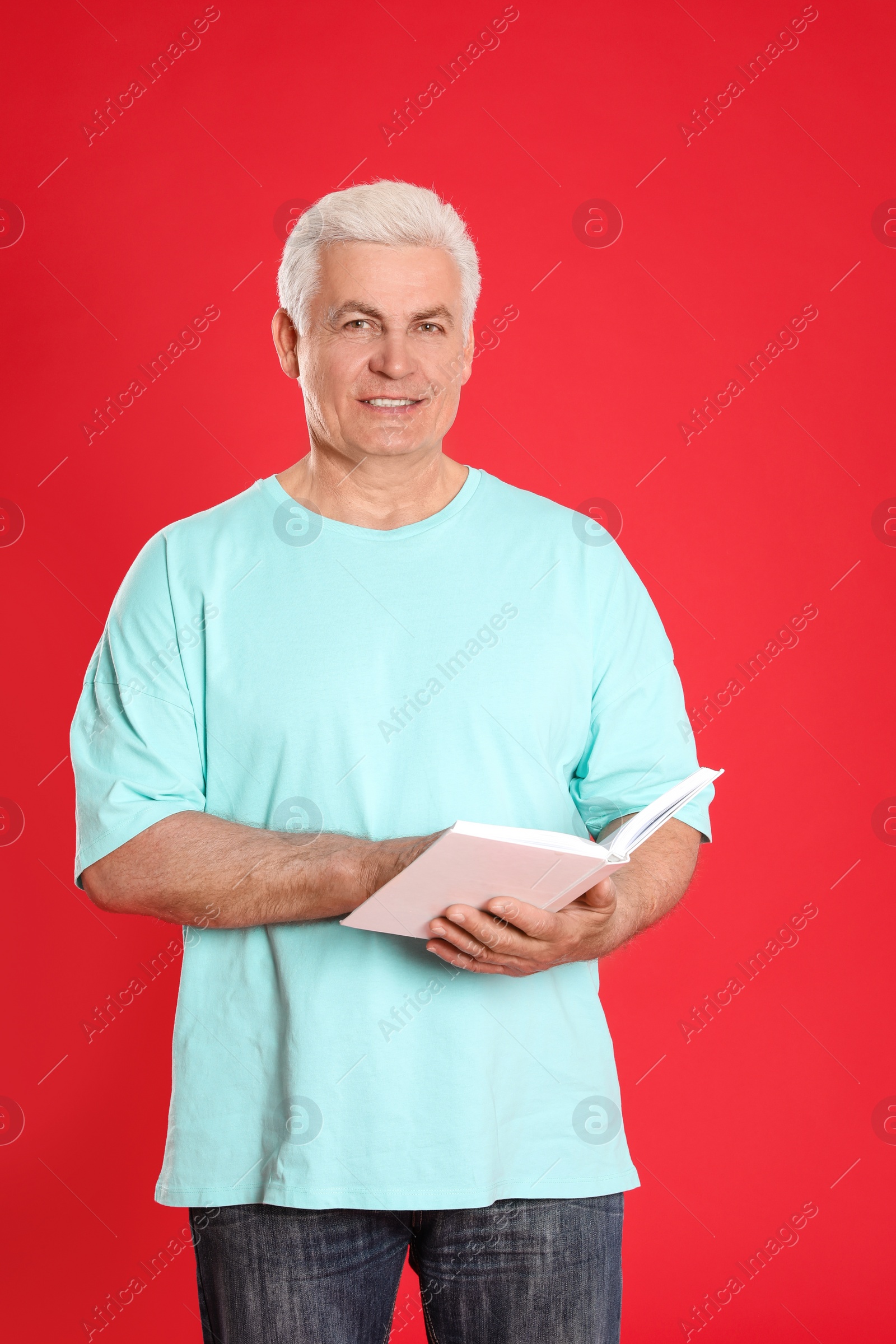 Photo of Senior man reading book on color background