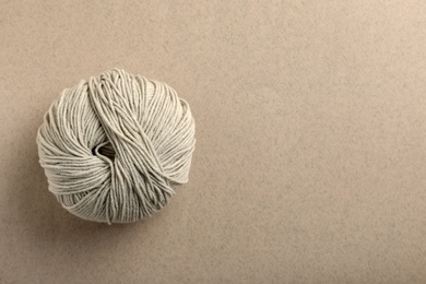 Soft woolen yarn on grey background, top view. Space for text