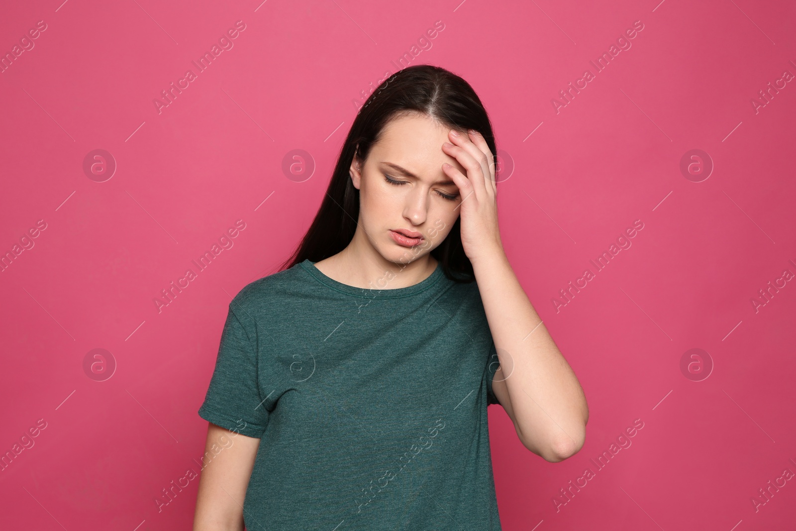 Photo of Portrait of young woman suffering from headache on color background