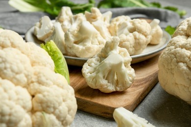 Photo of Cut fresh raw cauliflowers on grey table, closeup