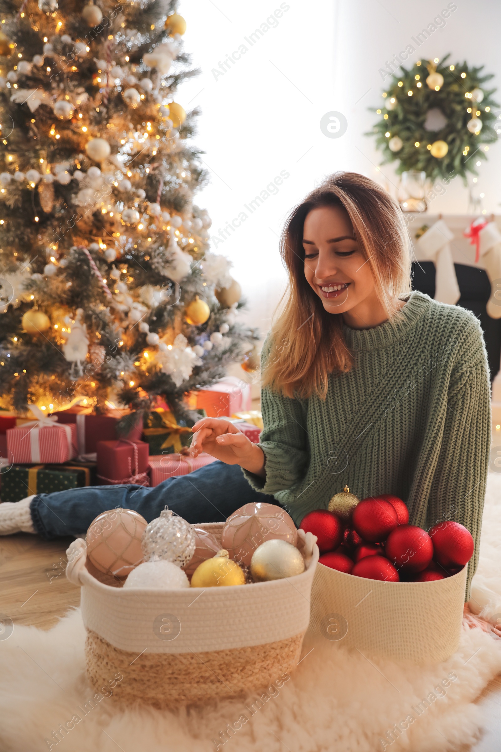 Photo of Beautiful woman decorating Christmas tree at home