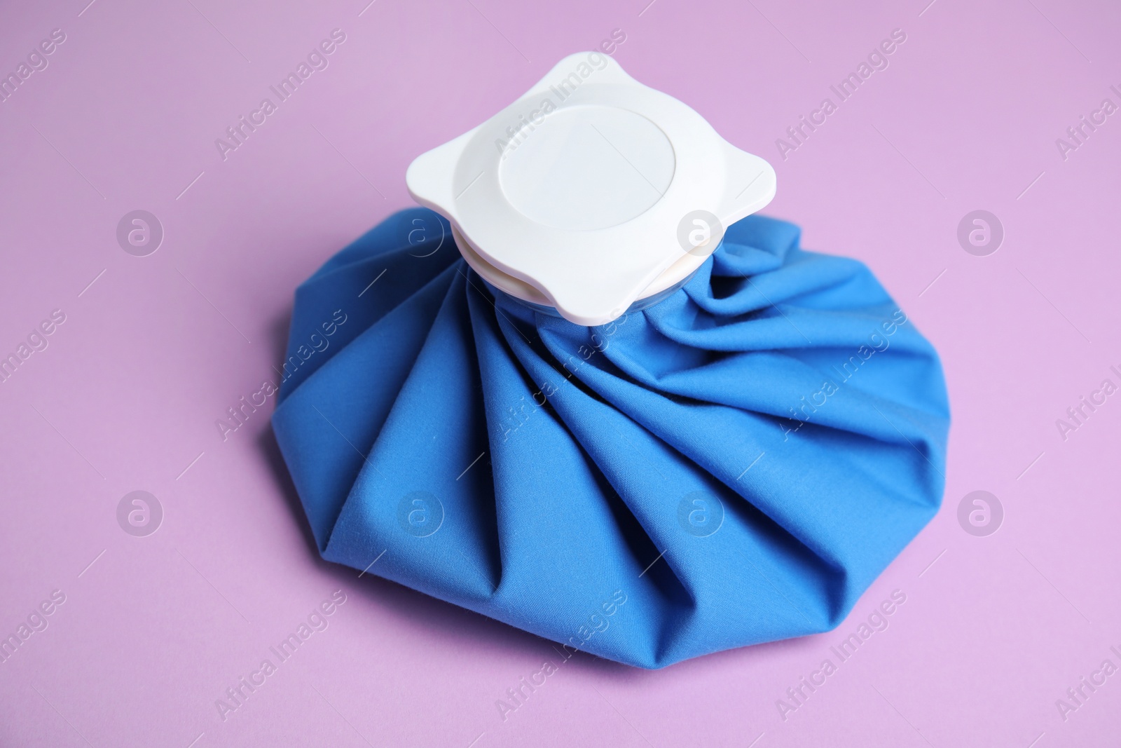 Photo of Ice pack on lilac background. Cold compress