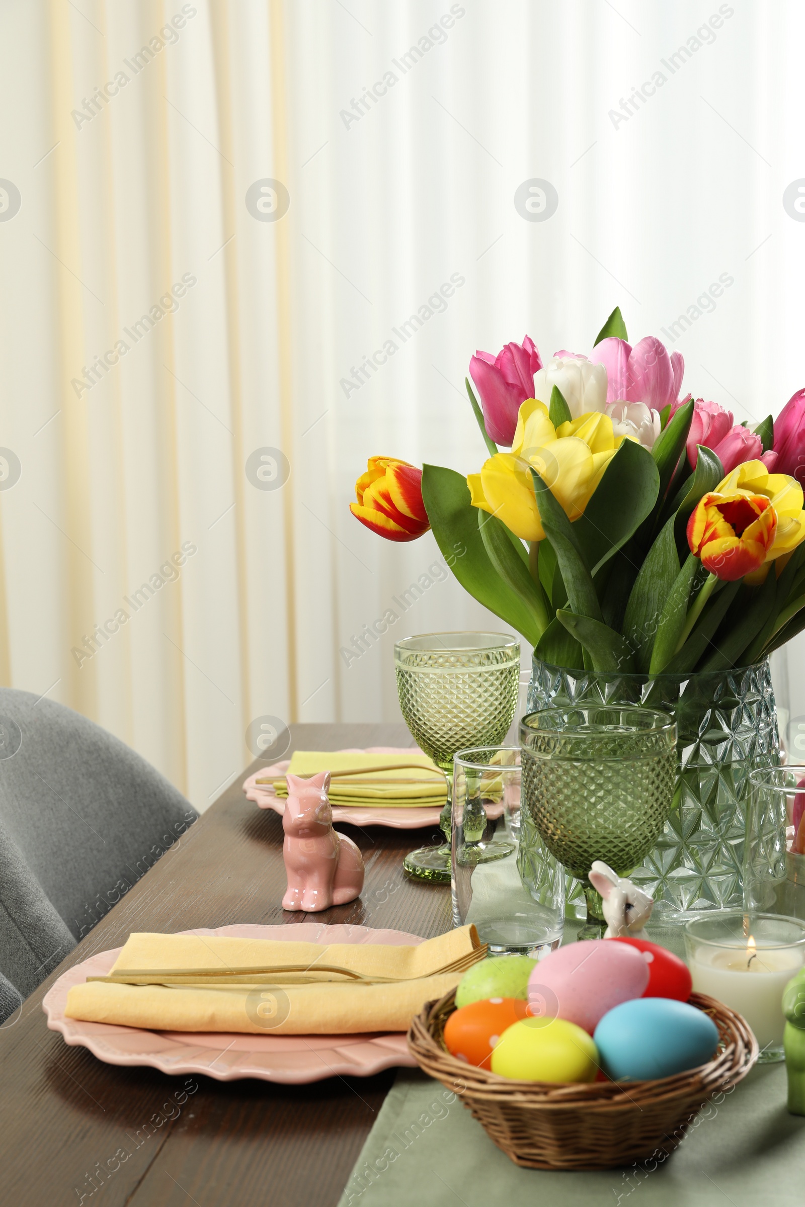 Photo of Easter celebration. Festive table setting with beautiful flowers and painted eggs