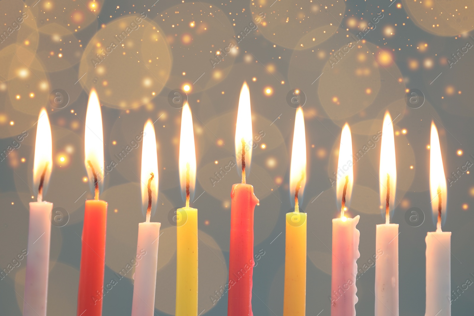 Image of Hanukkah celebration. Burning candles against blurred lights, closeup