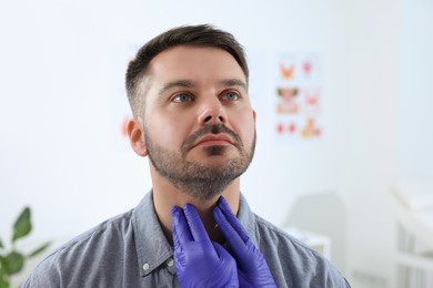 Endocrinologist examining thyroid gland of patient at hospital, closeup