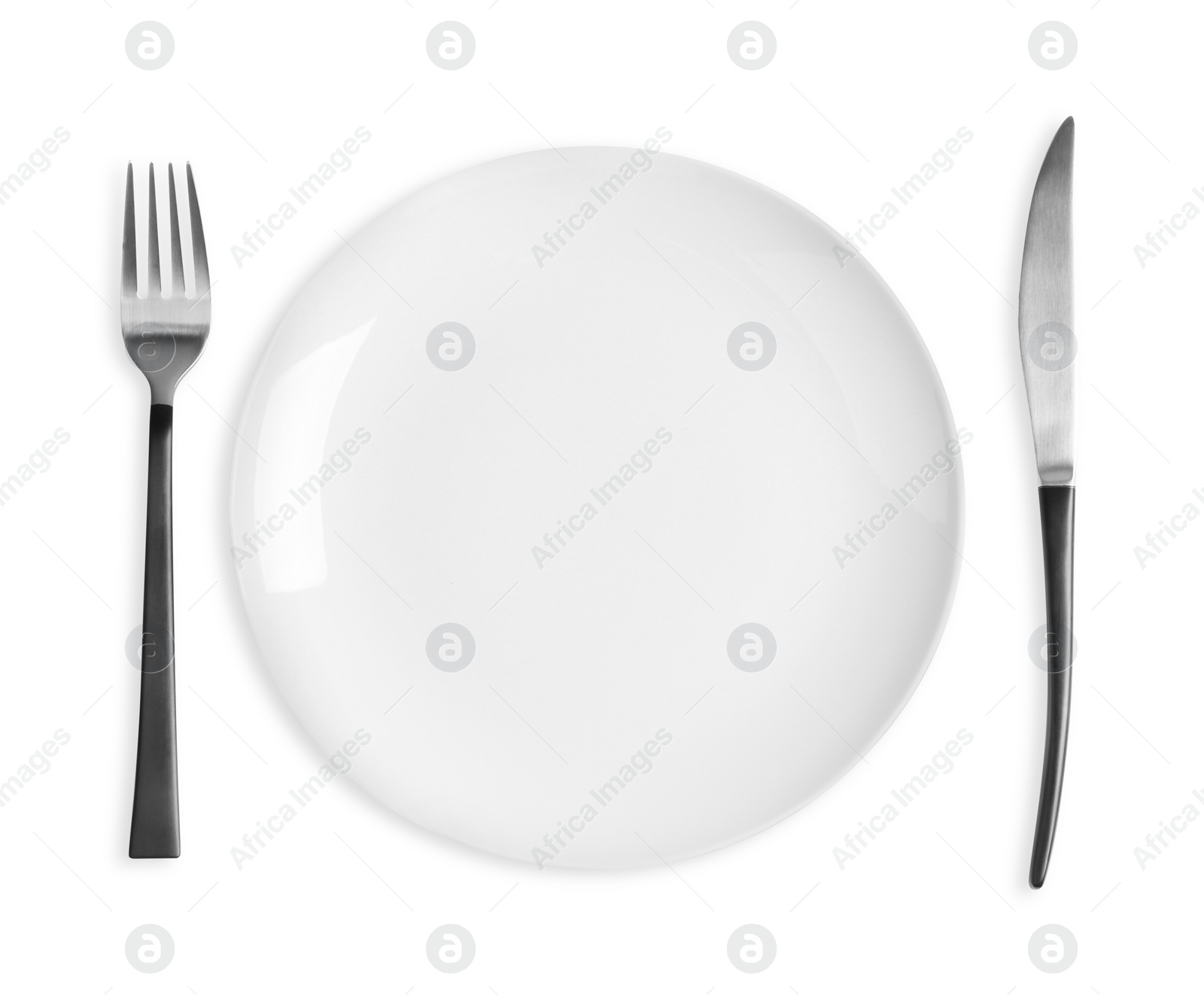 Photo of Empty plate, fork and knife on white background, top view