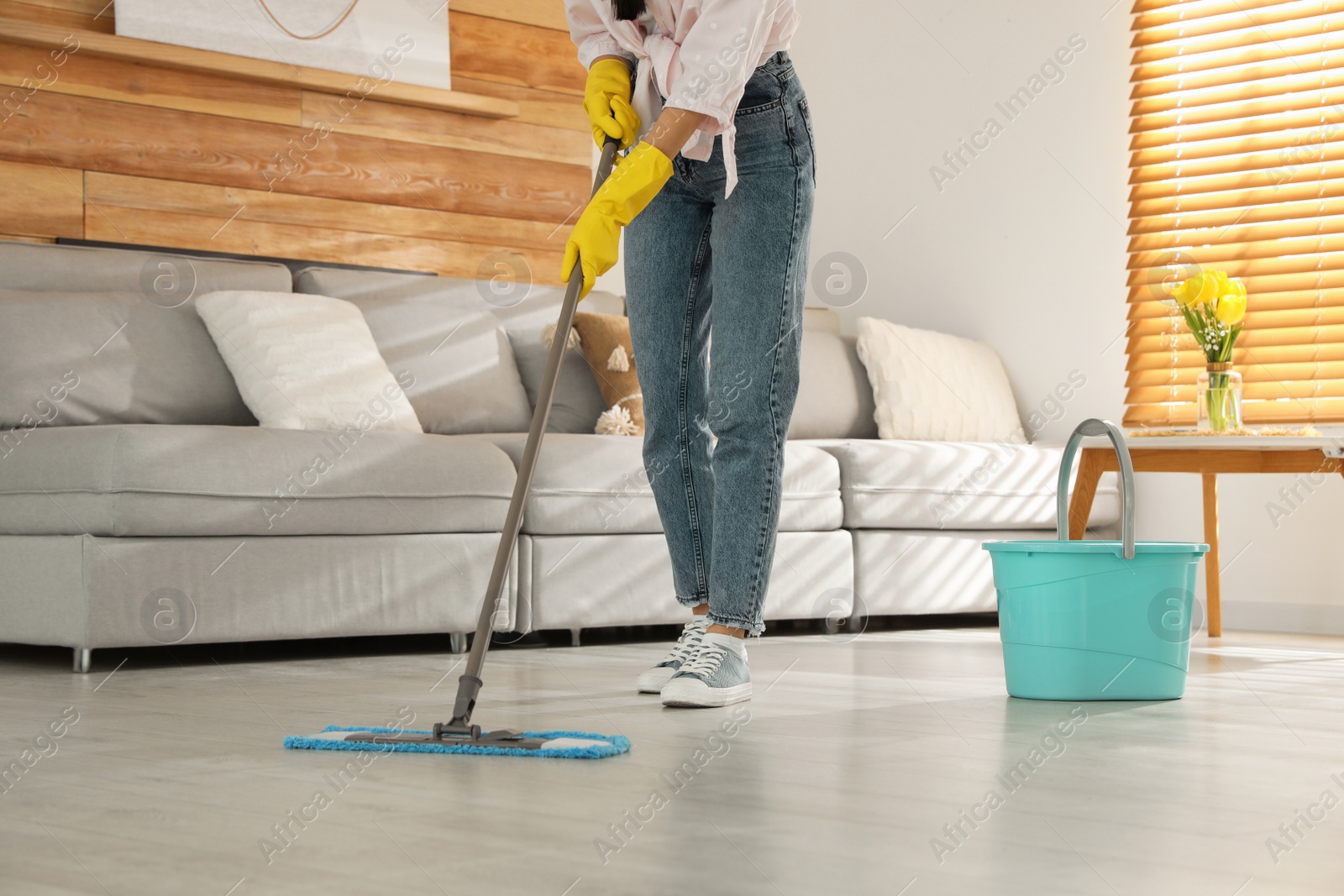 Photo of Woman cleaning floor with mop at home, closeup