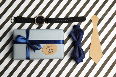 Flat lay composition with gift box and bow tie on striped background. Happy father's day