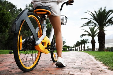 Photo of Young woman with bicycle on lane outdoors, closeup. Space for text