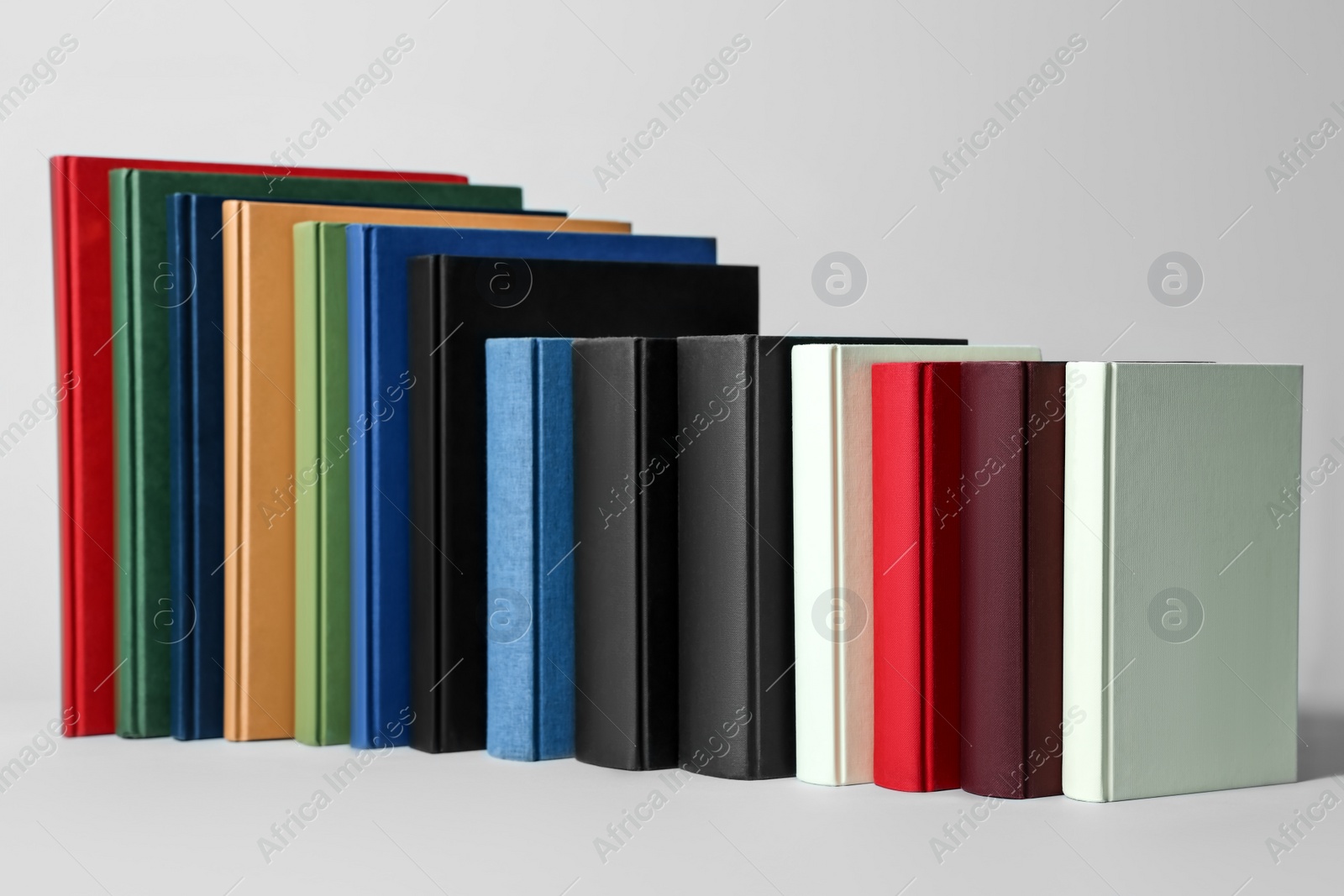 Photo of Many different hardcover books on light grey background