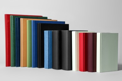 Many different hardcover books on light grey background
