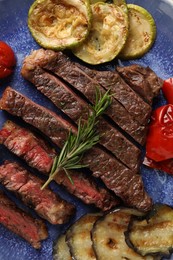 Photo of Delicious grilled beef steak with vegetables and spices on plate, top view